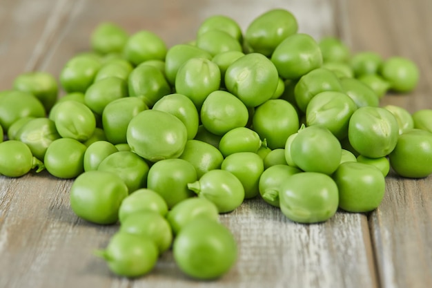 Fresh green peas heap on wooden background