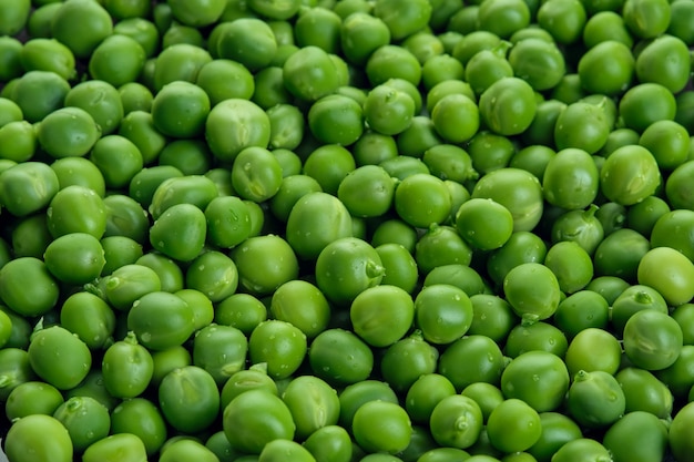 Fresh green pods or peas rotating peas background top view