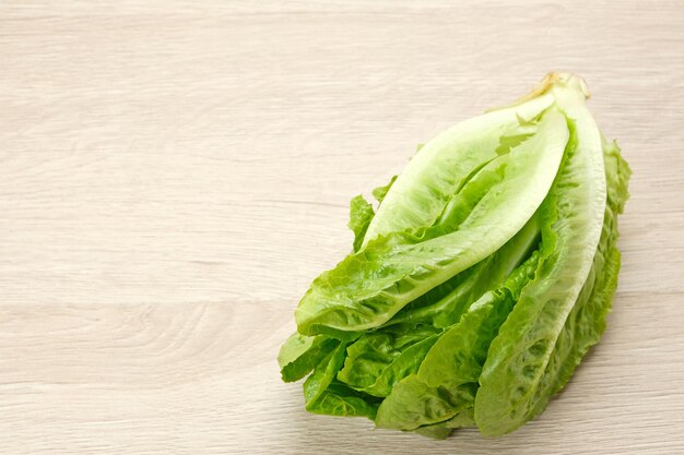 Fresh green romaine lettuce on a wooden background