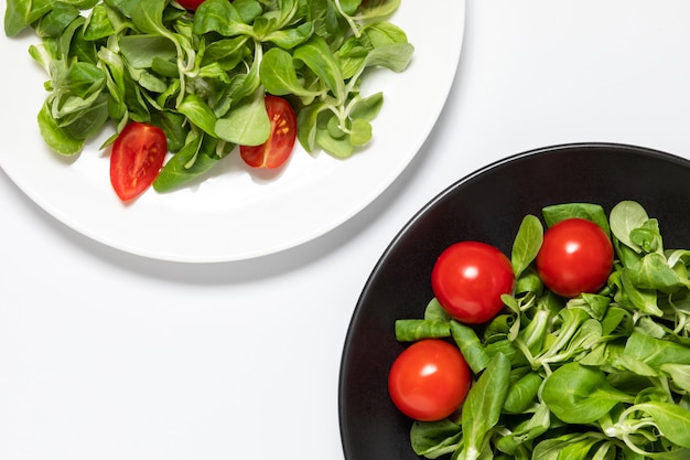 Fresh green salad with tomatoes on white 