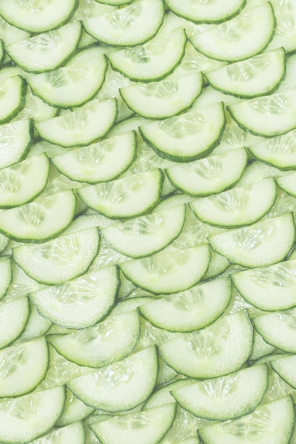 Fresh green slices of cucumber as background Top view