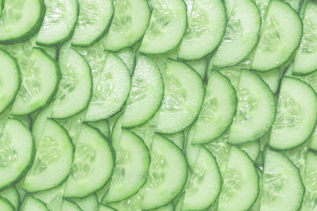 Fresh green slices of cucumber as background Top view