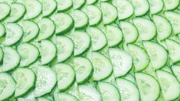 Fresh green slices of cucumber as background Top view