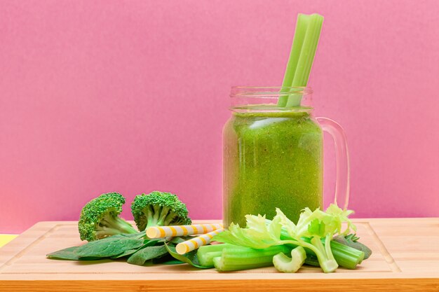 Fresh green smoothie of apple celery and spinach in glass smoothie jar