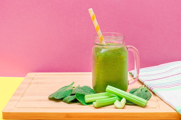 Fresh green smoothie of apple celery and spinach in glass smoothie jar