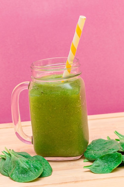 Fresh green smoothie of apple celery and spinach in glass smoothie jar