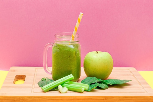 Fresh green smoothie of apple celery and spinach in glass smoothie jar