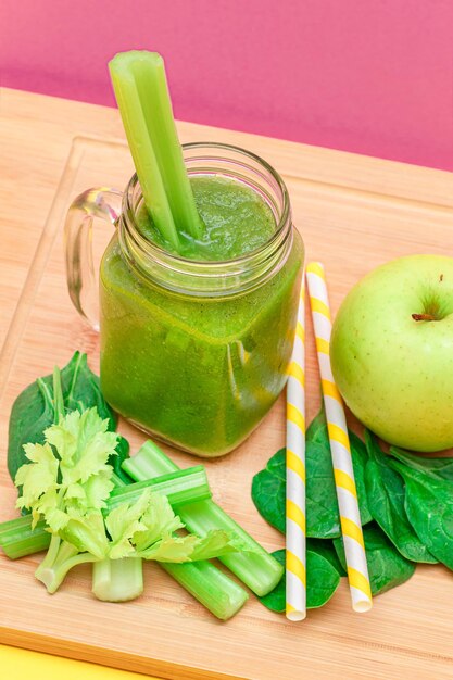 Fresh green smoothie of apple celery and spinach in glass smoothie jar