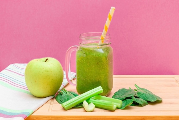 Fresh green smoothie of apple celery and spinach in glass smoothie jar