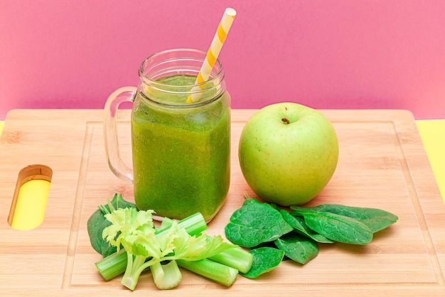 Fresh green smoothie of apple celery and spinach in glass smoothie jar