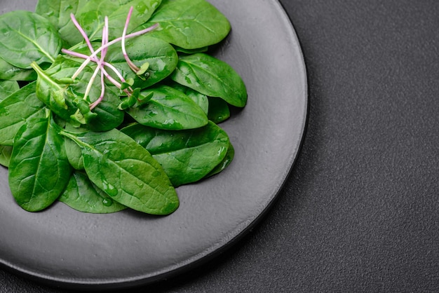 Fresh green spinach leaves on a black ceramic plate