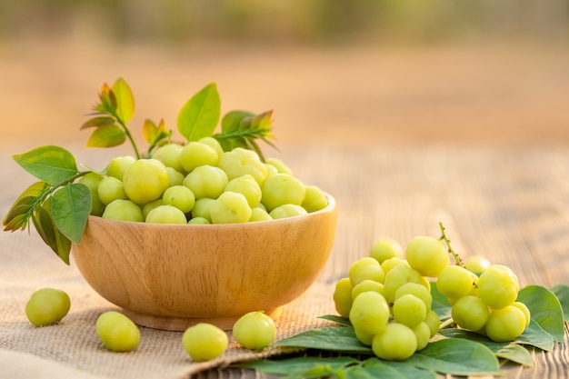 Fresh green star gooseberry (tropical Thai fruit) in bowl on wooden plank