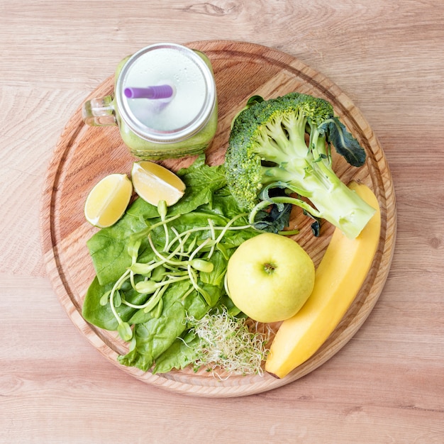 Fresh green vegetables and green smoothie in jar