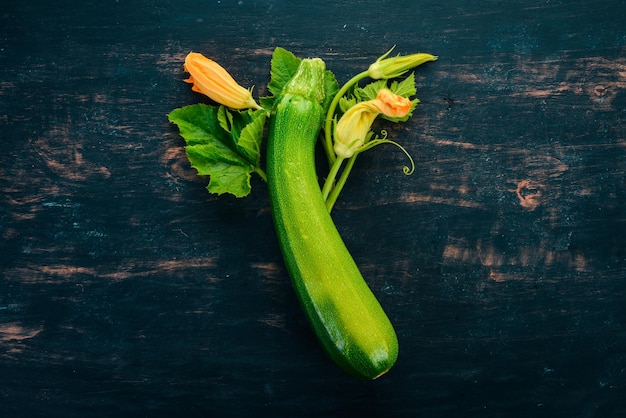 Fresh green zucchini on a black wooden table Top view Copy space