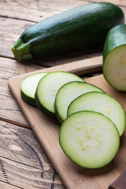 Fresh green zucchini cut into slices on a cutting Board.