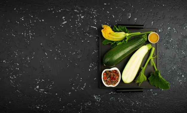 Fresh green zucchini on a dark table  in top view with copy space