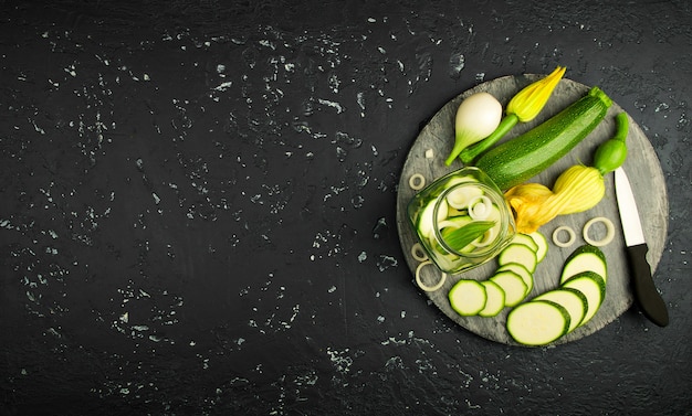 Fresh green zucchini on a dark table. The view from the top. Copy space.