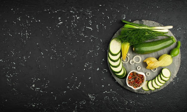 Fresh green zucchini on a dark table. The view from the top. Copy space.