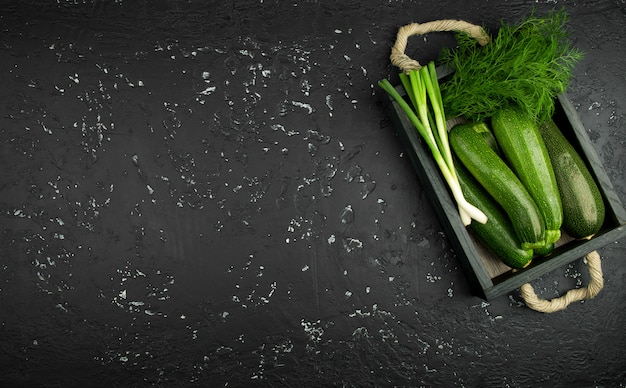 Fresh green zucchini on a dark table