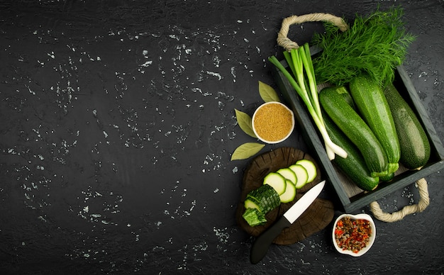 Fresh green zucchini on a dark table