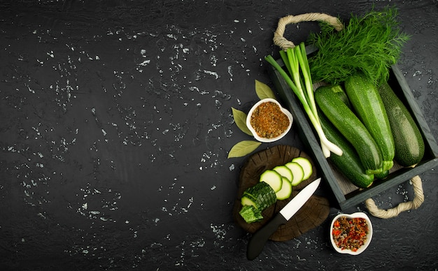 Fresh green zucchini on a dark table