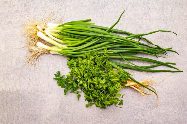 Fresh greens on a stone table, top view