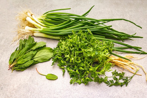 Fresh greens on a stone table, top view