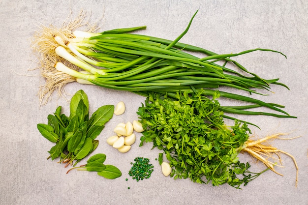 Fresh greens on a stone table, top view