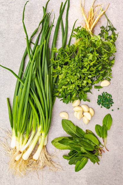 Fresh greens on a stone table, top view