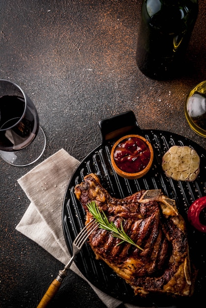 Fresh grilled meat beef steak with with red wine herbs and spices.  dark rusty background