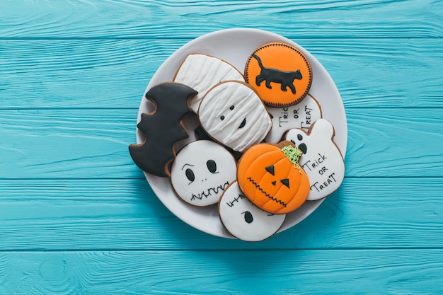 Fresh halloween gingerbread cookies on blue wooden table.