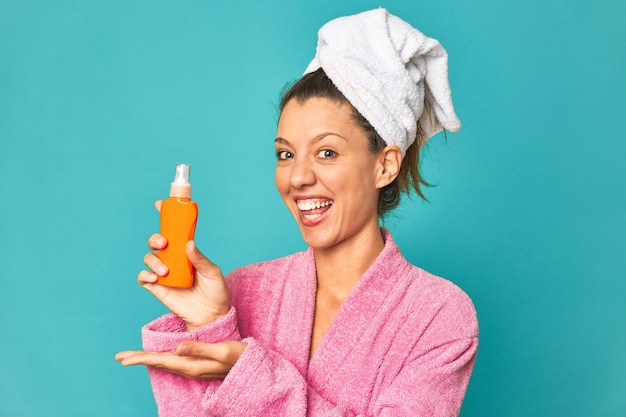 Fresh and happy woman holding sunscreen lotion