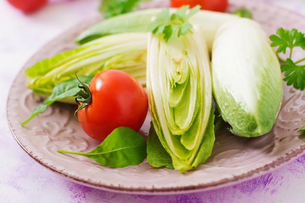 Fresh and healthy Chicory (witloof) Salad and tomato on a plate. Dietary menu. Healthy food.