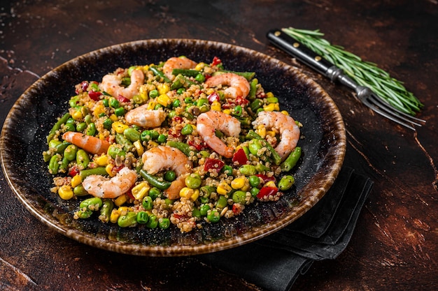 Fresh healthy food - Vegetarian salad with quinoa, vegetables and Shrimps, Prawns. Dark background. Top view.