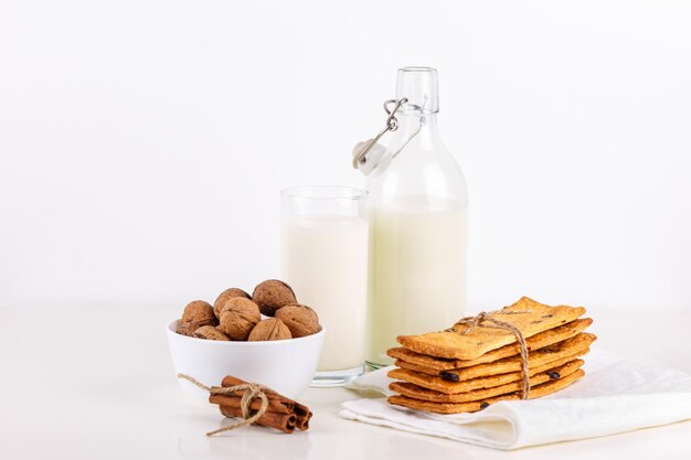 Fresh healthy milk cookies with raisins walnuts cinnamon sticks on white background selective focus