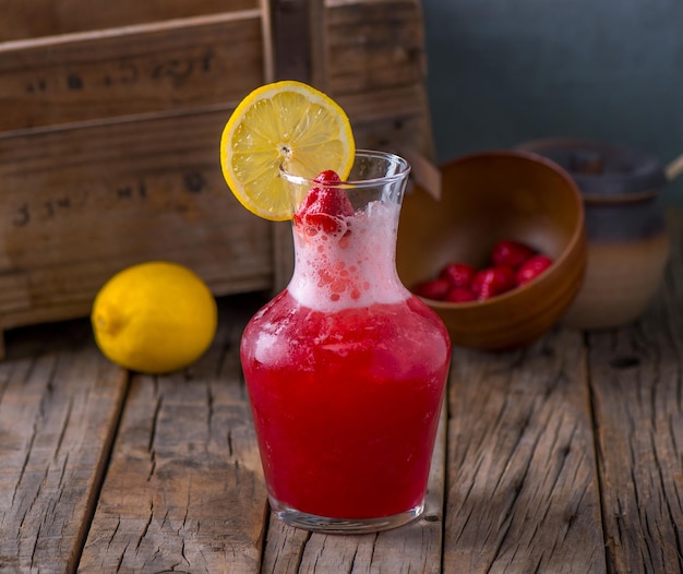 Fresh healthy SPARKLE juice Raspberry Mojito Lemonade with raw fruit served in jar isolated on wooden table side view