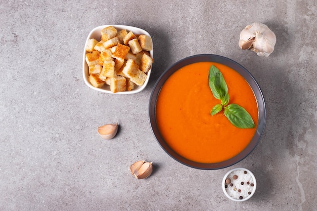 Fresh healthy tomato soup with basil pepper garlic tomatoes and bread on wooden background Spanish gazpacho soup Lentils and pumpkin soup