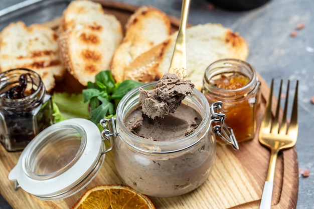 Fresh homemade chicken liver pate with pieces of white bread. Assorted Italian appetizer bruschetta. Food recipe background. Close up