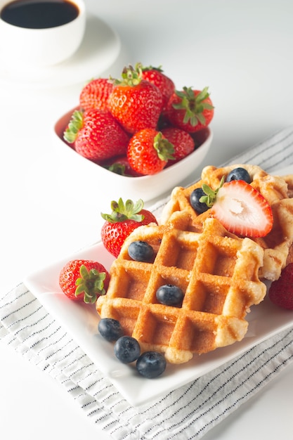 Fresh homemade food of berry Belgian waffles with honey chocolate strawberry blueberry