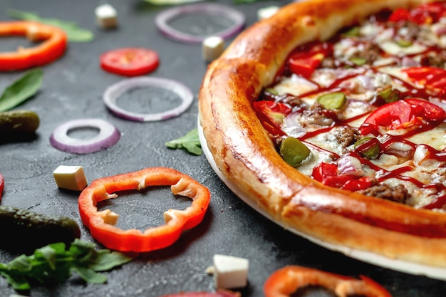 Fresh Homemade Italian Pizza Margherita with olives and red Bulgarian peppers on a dark background