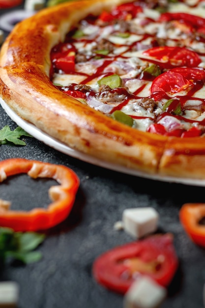 Fresh Homemade Italian Pizza Margherita with olives and red Bulgarian peppers on a dark background