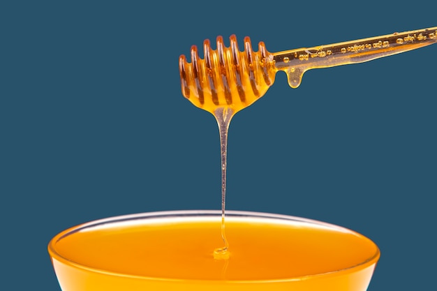 Fresh honey drips from a spoon into a plate. organic vitamin health food