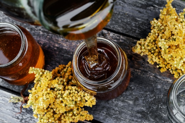 Fresh honey in glass jar on wooden background.