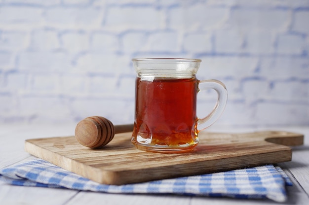 Fresh honey in a jar and wooden spoon on table