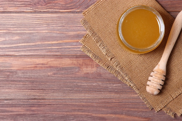 Fresh honey on the table closeup on a colored background