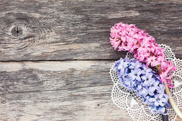 Fresh hyacinth flowers on aged wooden background. Top view