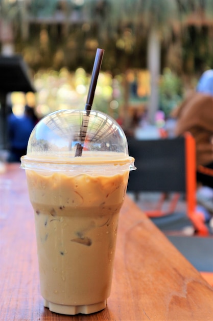 fresh ice coffee in plastice cup on wood table in the cafeteria