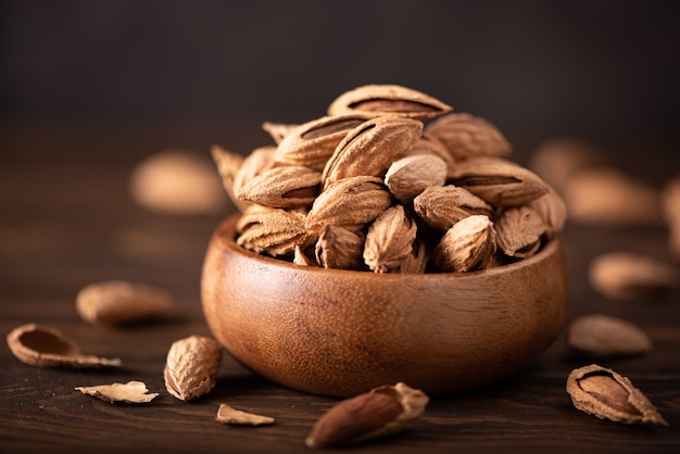 Fresh inshell almonds in a wooden bowl