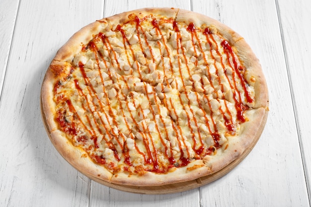 Fresh italian pizza with chicken on wooden table