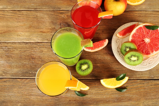 Fresh juices with fruits on wooden table